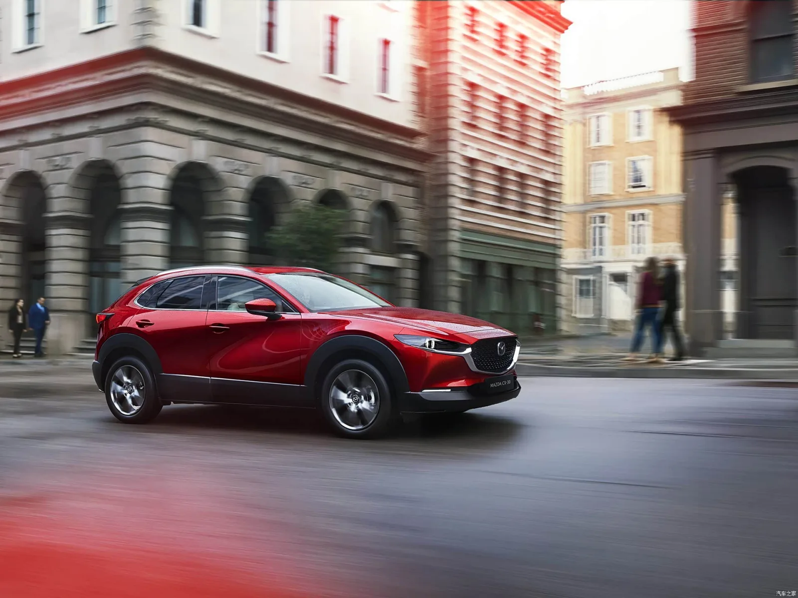 Mazda CX-30 2026 в движении по городу — вид сбоку